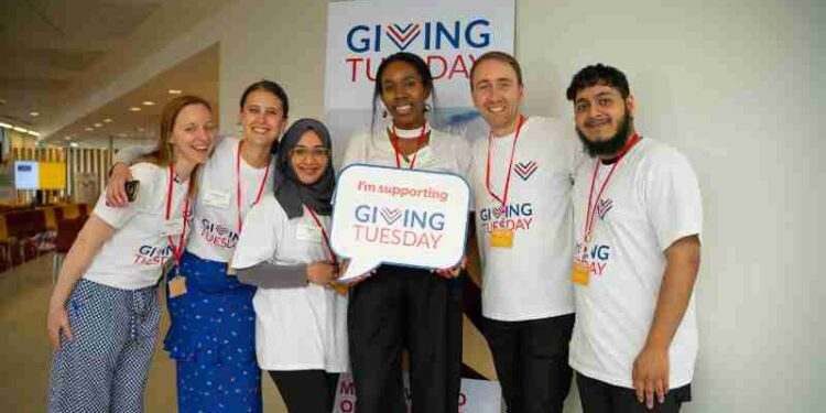 Diverse group of adults supporting Giving Tuesday with enthusiasm indoors., tags: 2025 - pexel