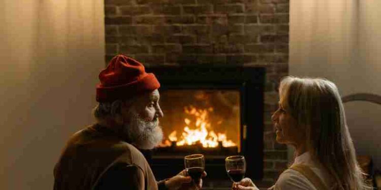 Charming scene of a senior couple sharing wine by a warm fireplace. Cozy and romantic., tags: wohltätigkeitsorganisation für - pexel